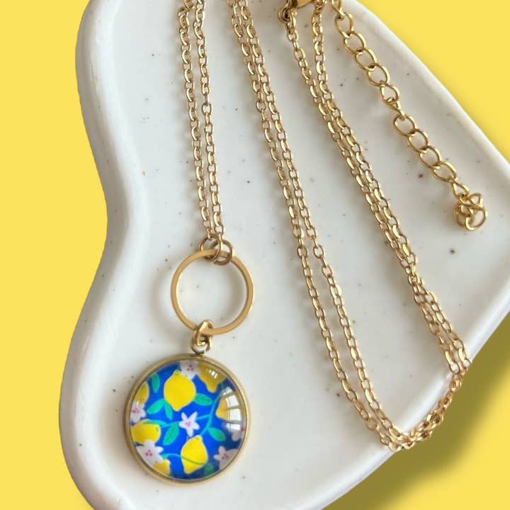 Collier citrons jaunes sur fond bleu, finition dorée ou argentée pour la vente par Dans l'Air du Temps Bijoux