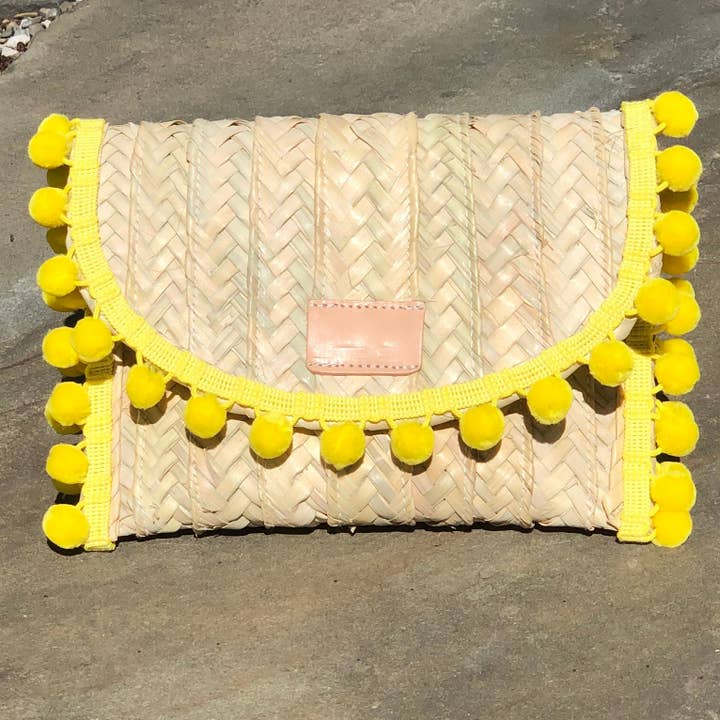Bolso de mano de paja Penélope con ribete de pompones amarillos para venta al por mayor de Oriana Lamarca Designs