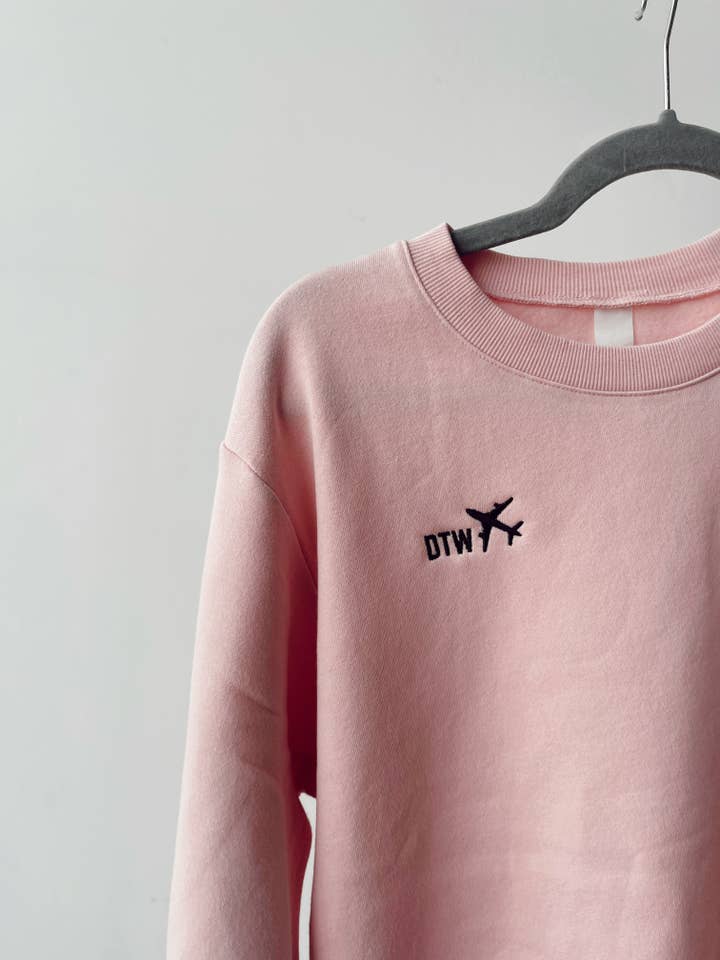 Veste douillette haut de gamme rose brodée en forme d'avion pour la vente par Kiloh + Co.