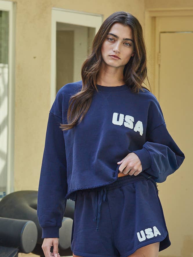 Pull-over en coton tricoté à col rond avec patch USA By Together pour la vente par By Together