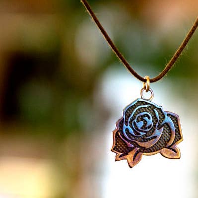 Mighty Rose indfyldt vedhæng halskæde i iriserende finish på justerbar naturfiberledning for engroshandel hos From War to Peace