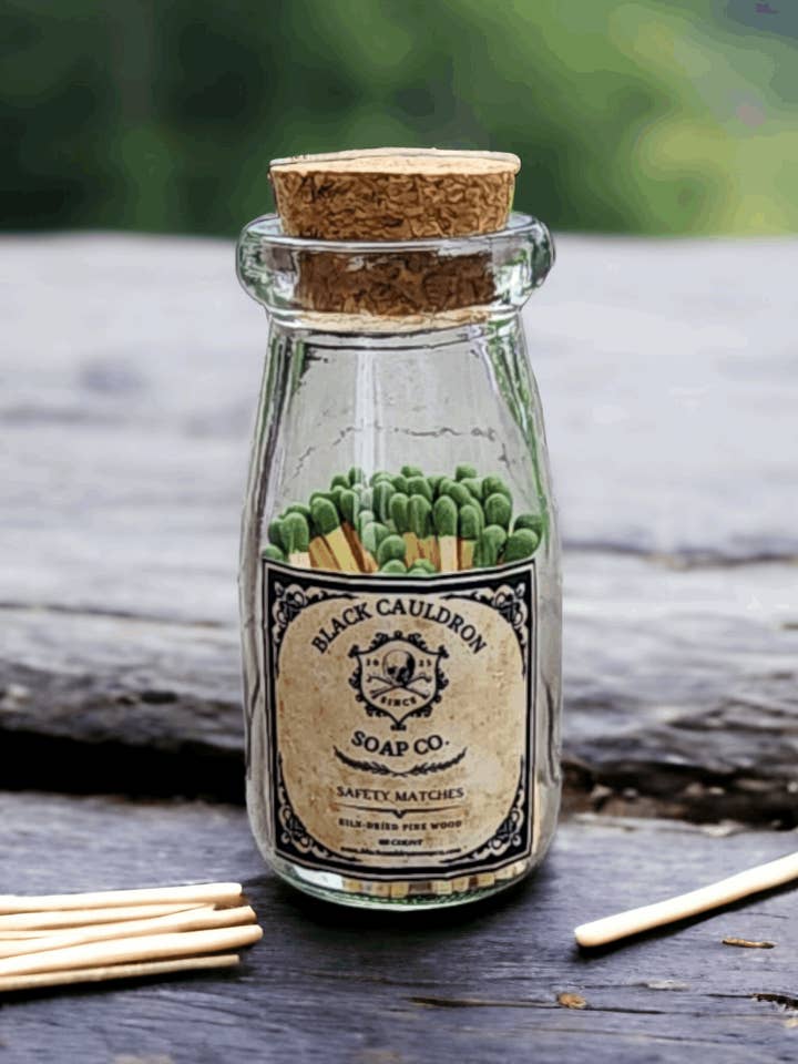 Cerillas de boticario en una botella de vidrio para tintura con tapa de corcho, chimenea para encender fuego, caldero negro rústico para venta al por mayor de Black Cauldron Soap Co.