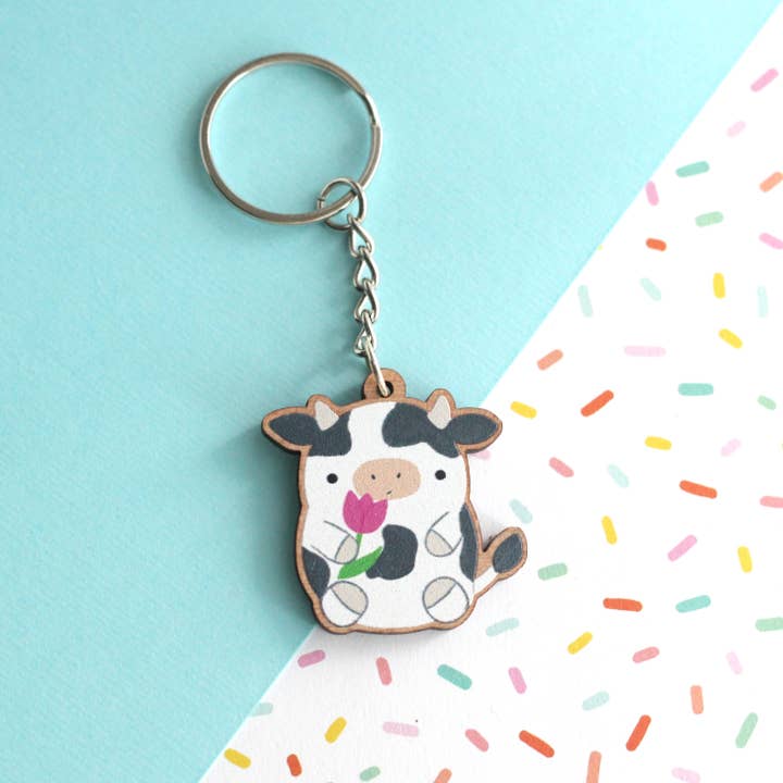 Cow holding a Tulip Wooden Keychain. Cute Cow Wood Charm for wholesale by Wild Whimsy Woolies