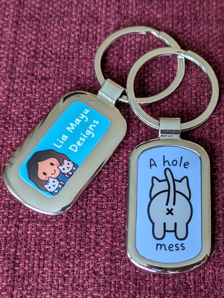 A hole mess cat butt pun metal keychain for wholesale by Lia Mayu Designs