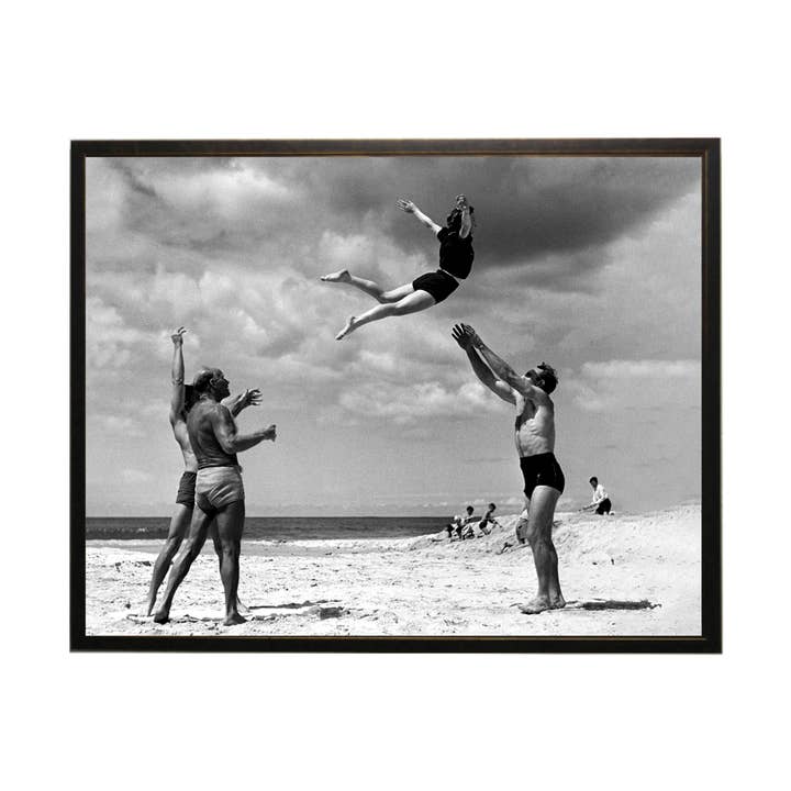 Vintage black and white photo of men tossing woman for wholesale by Antique Curiosities Inc