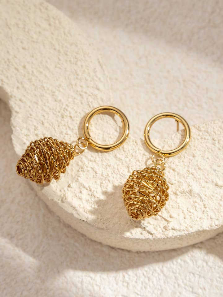 Gold dangling hoop earrings with sculpted spirals for wholesale by COSMOS