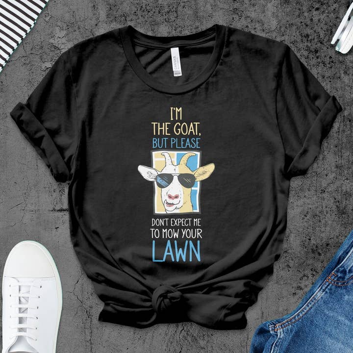 Sjov gede-T-shirt, I'm The Goat But Please Don't Mow Lawn Tee, Quirky Animal Humor, Cool Sunglasses Grafisk Skjorte for engroshandel hos FreakyTeeFactory