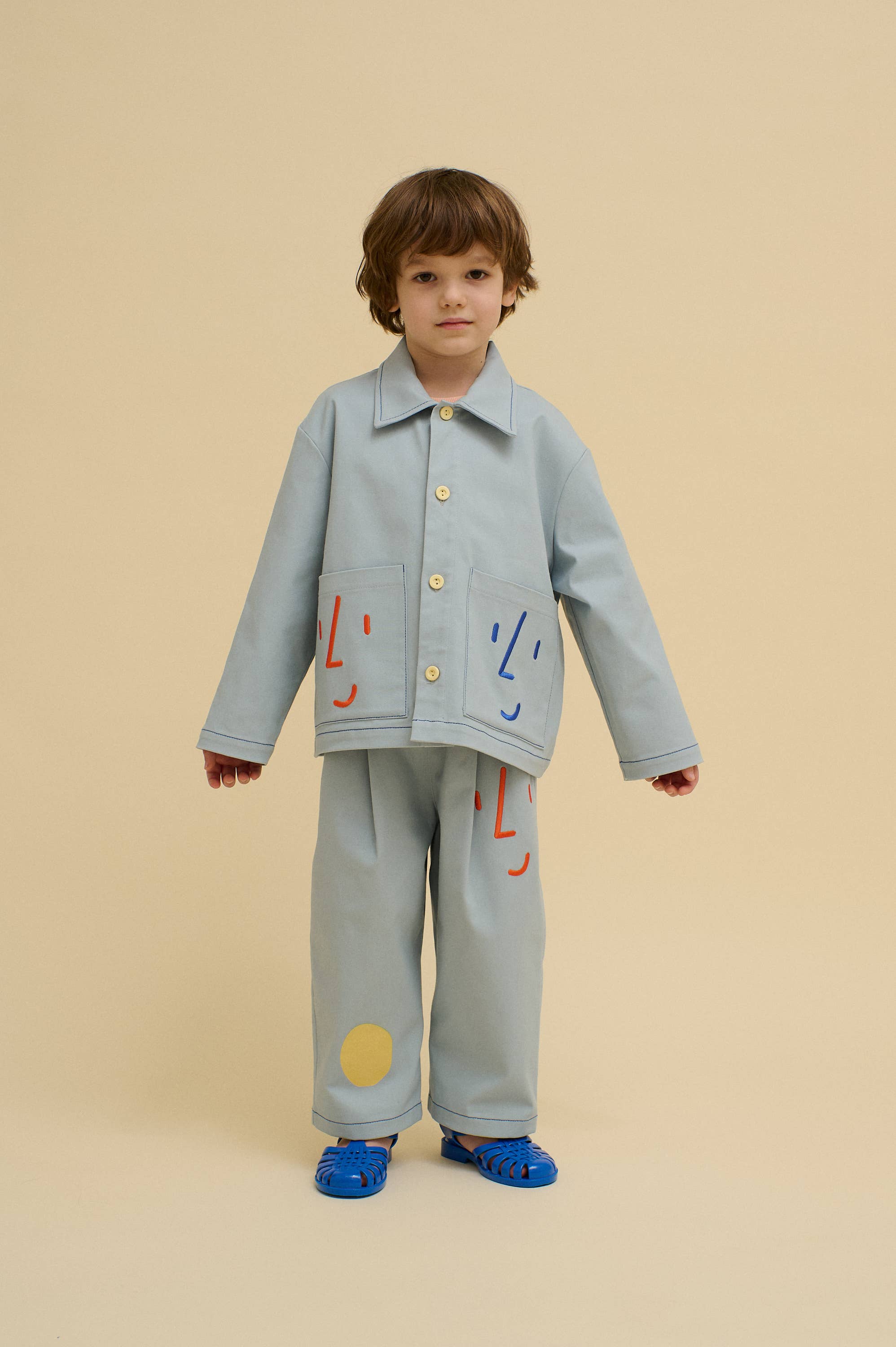 Blauw Utility jas met speelse geborduurde gezichten voor groothandel op Faire1