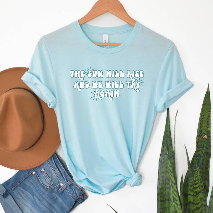 The Sun Will Rise - Baby Blue Bella Canvas Tee for wholesale by Bakers and Burgers