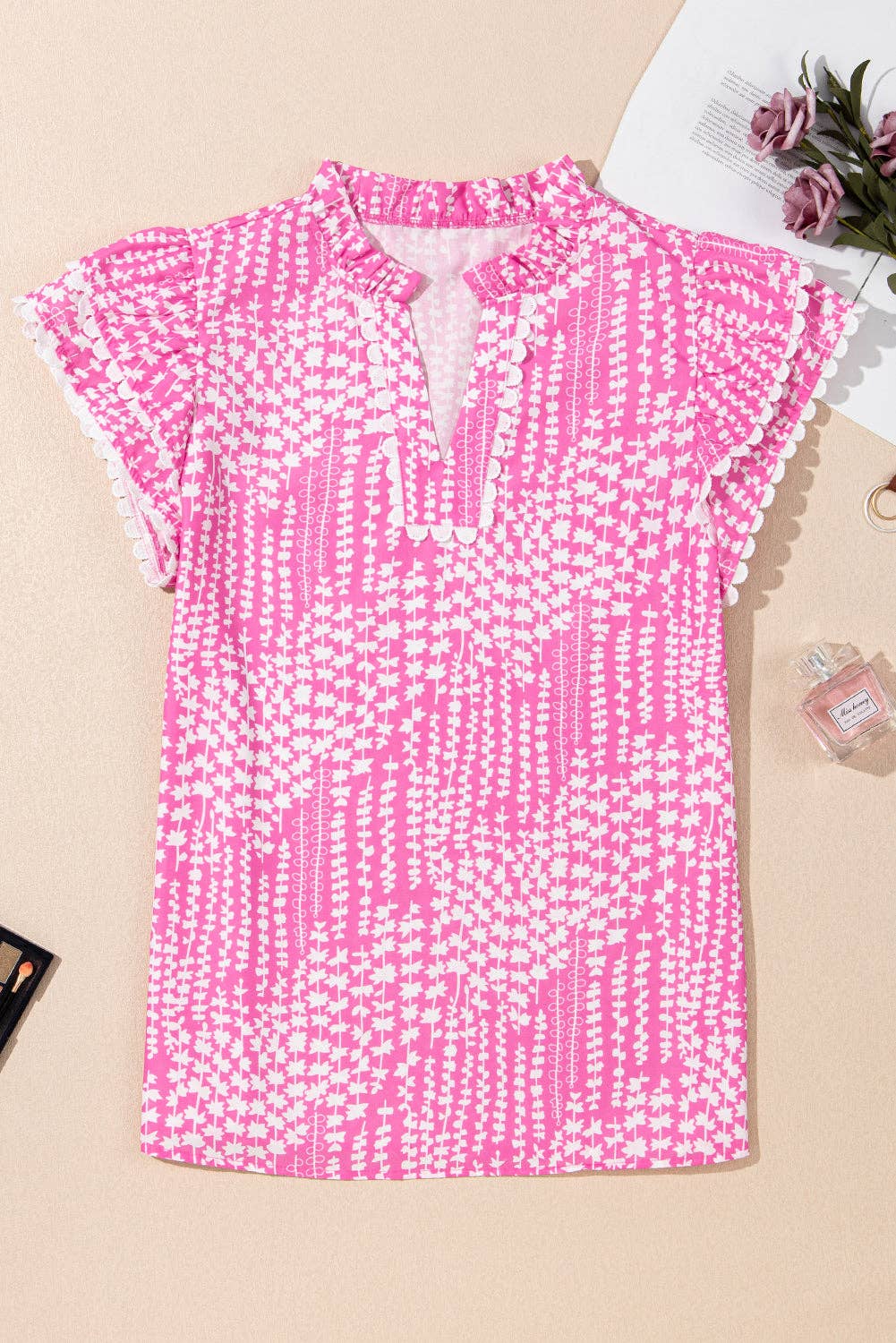 Rosa Blus med abstrakt tryck, ric rac-kant, fladdrande ärmar och V-ringning med skåra. för wholesale på Faire3