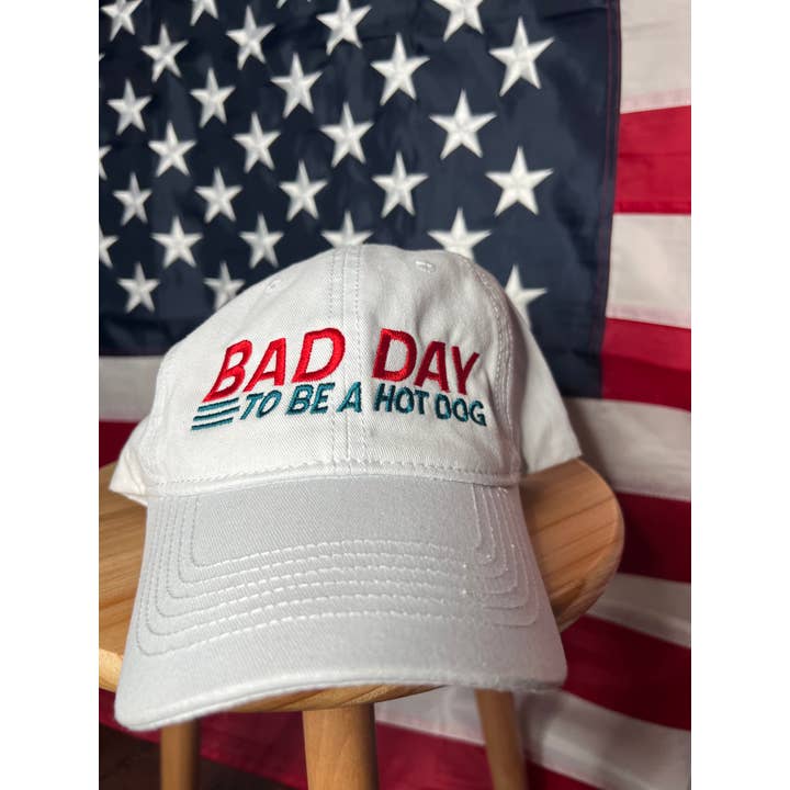 Cappello da papà ricamato «Bad Day to Be a Hot Dog» bianco per la vendita all'ingrosso da parte di LA PRINT AND STITCH