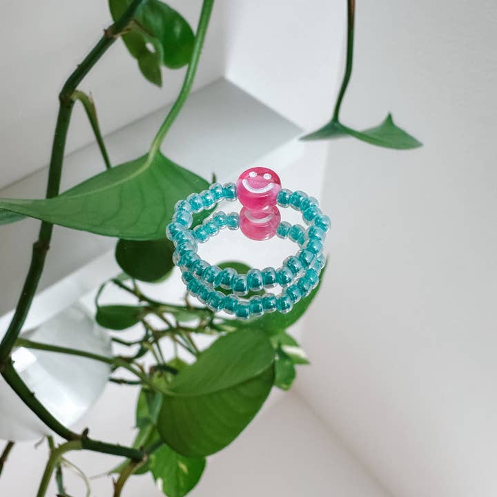 Aqua glass pearl ring with pink smiley for wholesale by cool people club