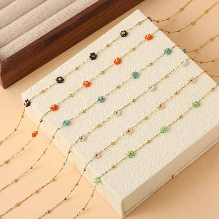 Sæt med 6 farverige blomsterhalskæder på display for engroshandel hos joya