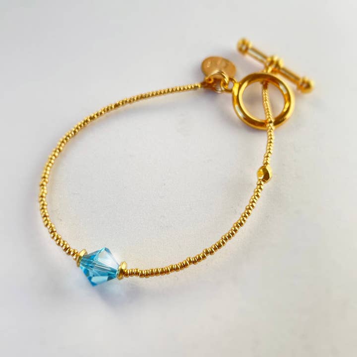 2021-A01-041 - Petite Marie - Pulseira - Ouro - Cristal aqua por atacado de Petite Marie Jewelry