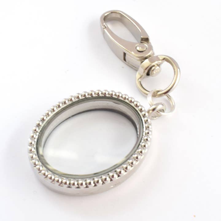 Amaya Rose Ltd. - Vente Porte-clés – femme - Porte-clés médaillon flottant ovale en argent. Bijoux à breloques