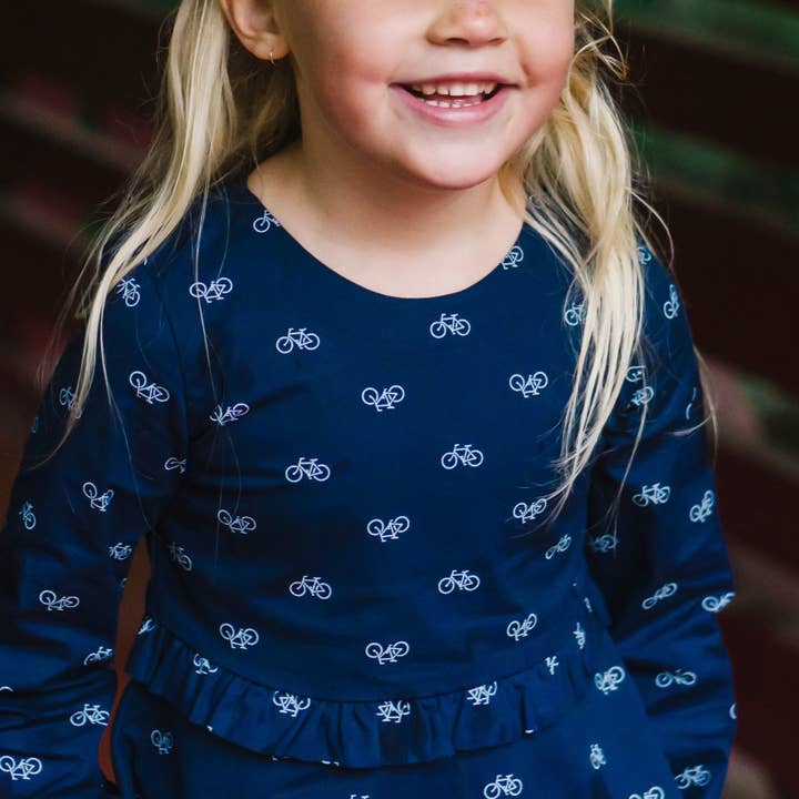 Navy Bicycle Print Ruffle Waist Dress - Made with Organic Cotton for wholesale on Faire