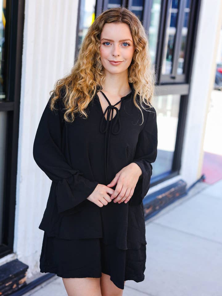 Zwarte jurk met gelaagde rok en strik aan de voorkant voor wholesale door Promenade