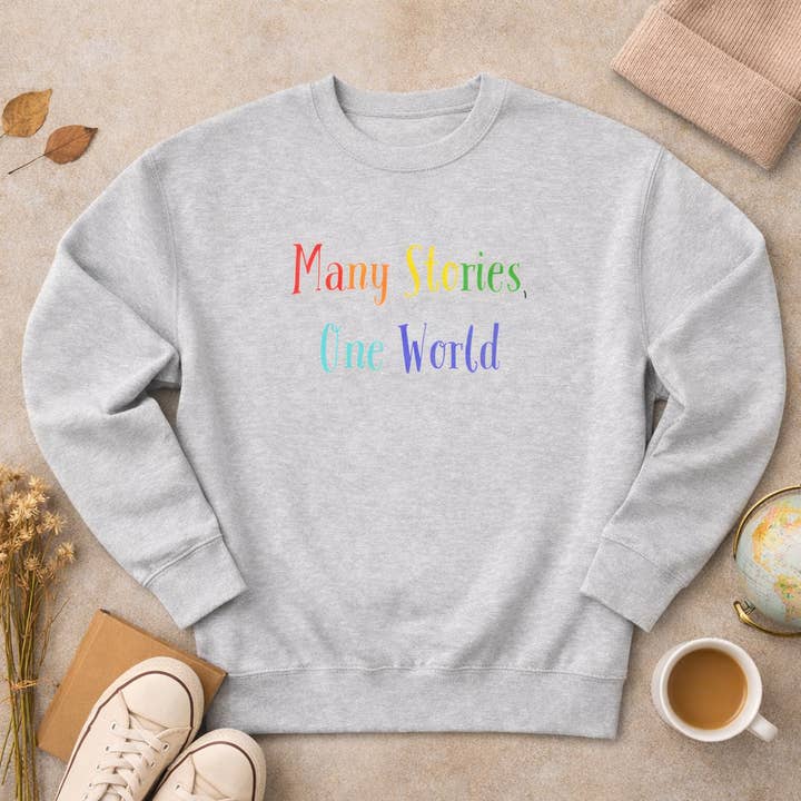 'Sudadera Unisex de Cuello Redondo "Muchas Historias, Un Mundo"' para venta al por mayor de Cray Clothing Company