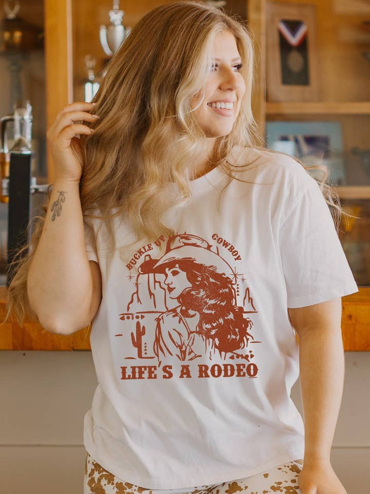 Life's A Rodeo on White Tee Shirt for wholesale by GRACE+EMMA by Southern Grace