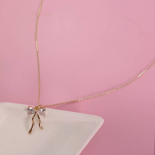 Gold PETITE RHINESTONE BOW NECKLACE | 80N600 for wholesale on Faire