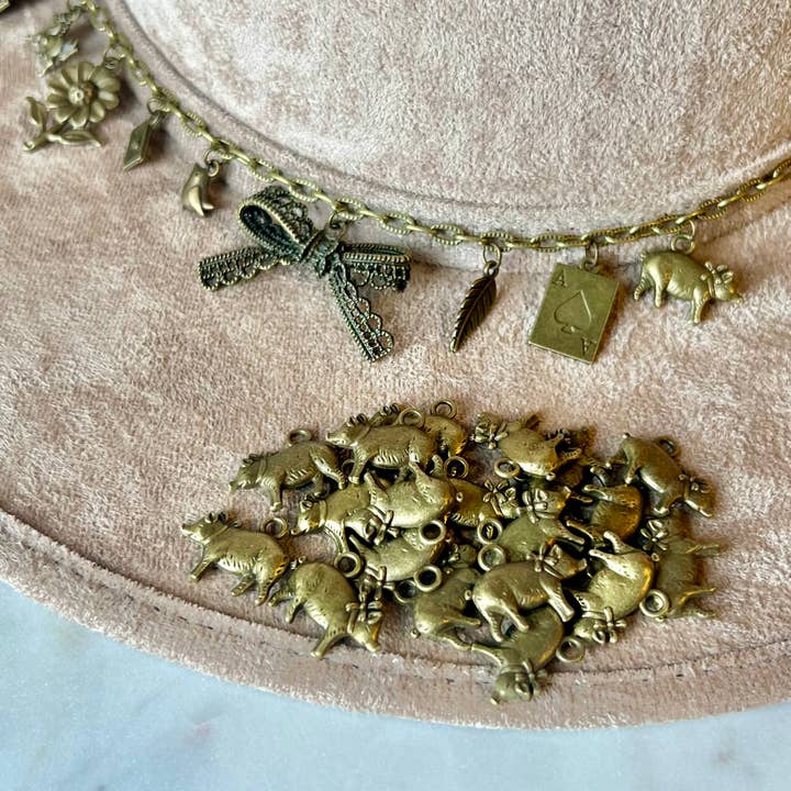 Pendentif Cochon avec Nœud Bronze pour la vente par Brand Dandee