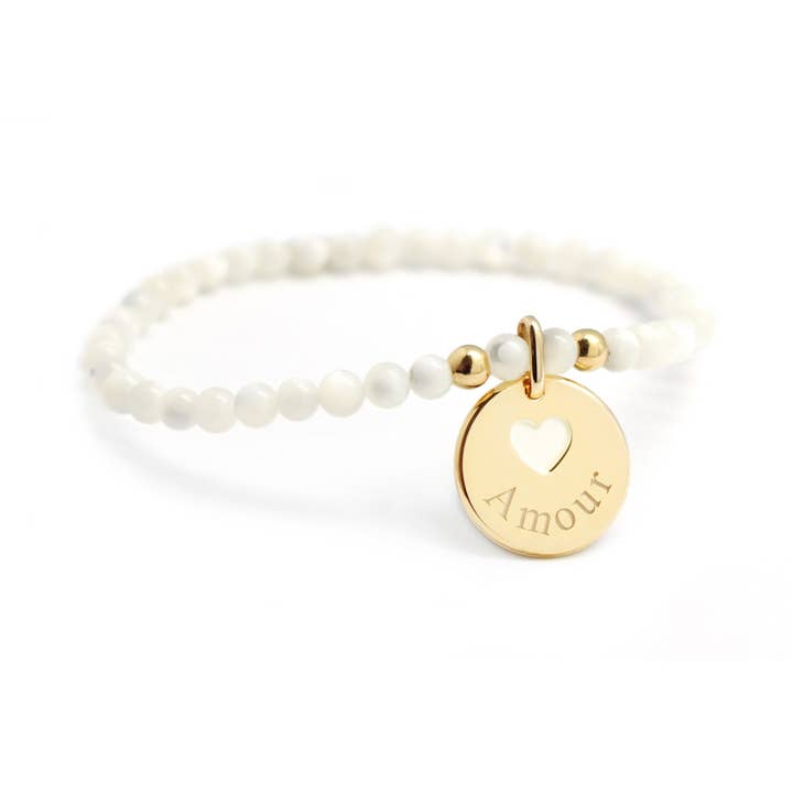 Bracciale con perle di madreperla bianca e medaglia a cuore dorata incisa 'Amour' per la vendita all'ingrosso da parte di Petits Trésors