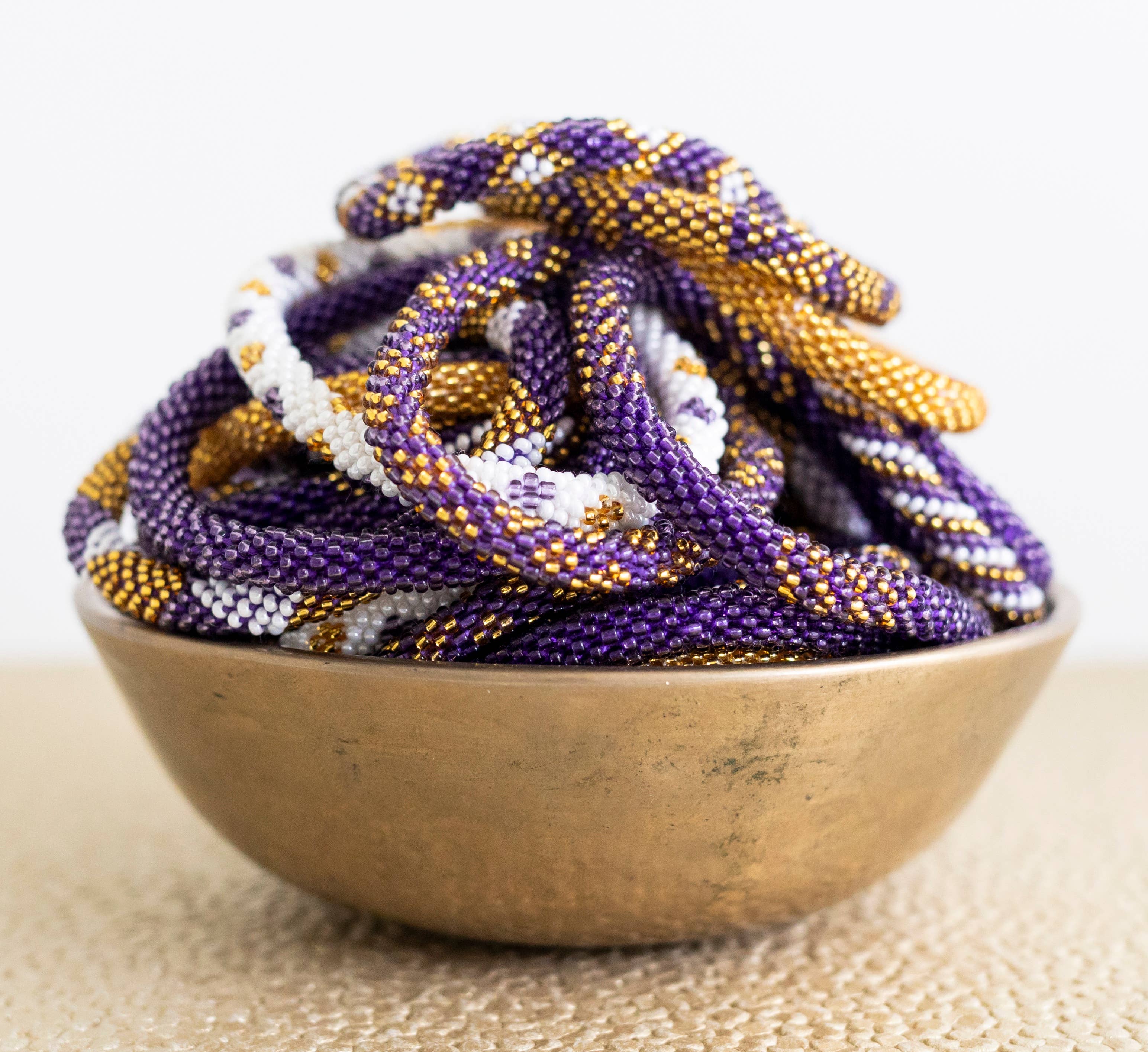 Aid Through Trade - Wholesale Jewelry Set - Roll-On® Game Day Bracelet Purple and Gold - Set of 121