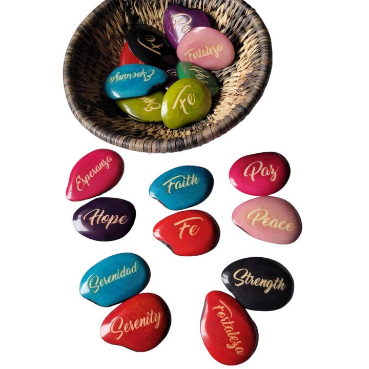 Multi Colored Faith engraved riverstones tagua nuts in Spanish for wholesale on Faire