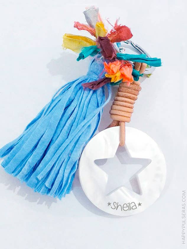 Schlüsselanhänger aus weißem Perlmutt mit einem gravierten hohlen Bommelstern. für den Großhandel von Happypulseras