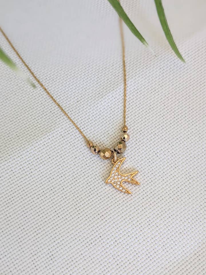 Collana SAINT REMY con rondine e perle dorate per la vendita all'ingrosso da parte di L'Arbre du Voyageur Bijoux