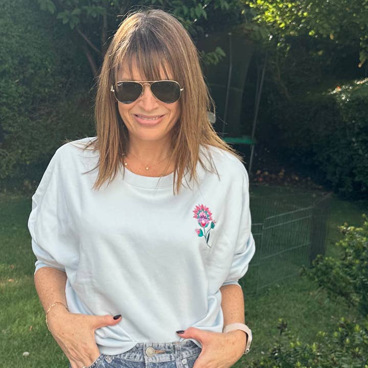 Økologisk babyblå sweatshirt med blomst for engroshandel hos Percy and Nell Retail Limited