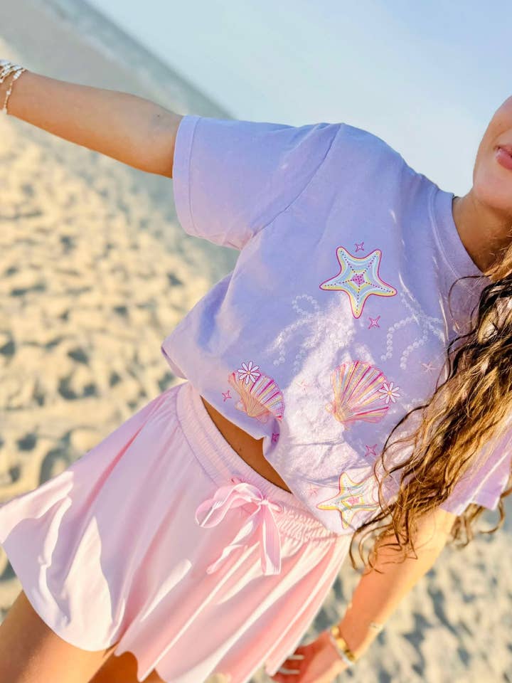 Maglietta grafica con fiocco di perle e conchiglie. per la vendita all'ingrosso da parte di Dash Forward Wholesale