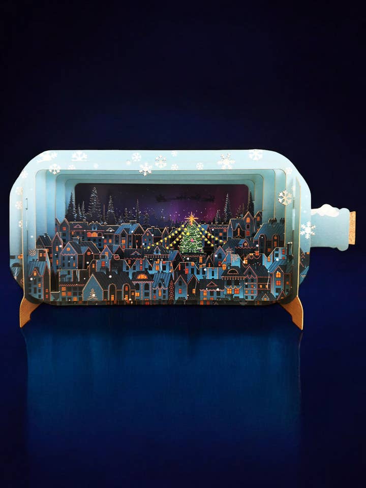 CARTE DE VŒUX MESSAGE DE NOËL DANS UNE BOUTEILLE SCÈNE DE VILLE pour la vente par Notes & Queries, Inc.