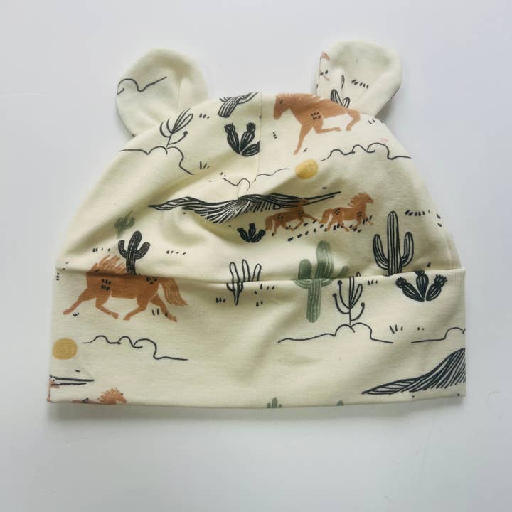 PRÉCOMMANDE POUR LIVRAISON 1ère SEMAINE DE FÉVRIER. Chapeau pour bébé en coton biologique Eddie & Bee avec oreilles en crème imprimé "Wild West". pour la vente par Eddie & Bee