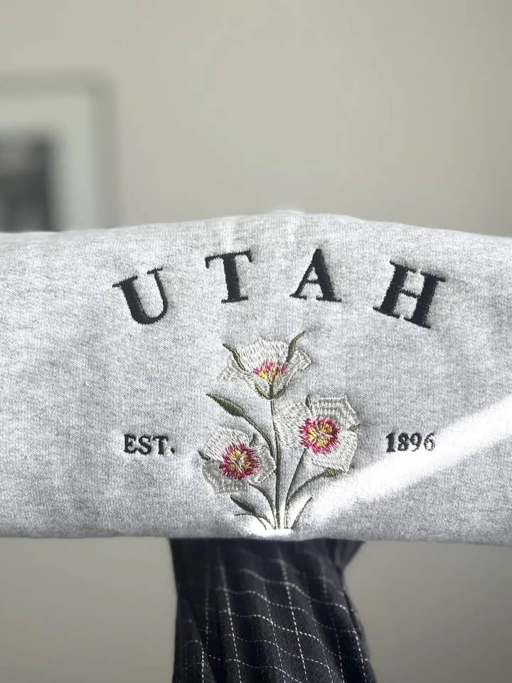 Felpa Ricamata con Fiore dello Stato dello Utah: Sego Lily per la vendita all'ingrosso da parte di Poppy Bloem