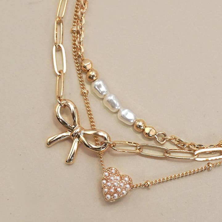 Gold CHARM BRACELET-MULTI LAYER BOW PERAL HEART CHARMS | 80B1317 for wholesale on Faire