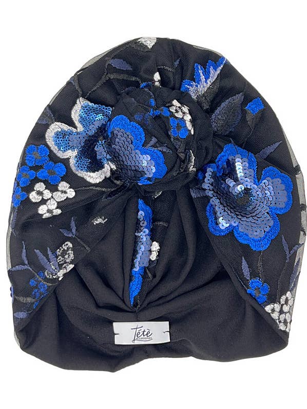 Zwarte satijnen tulband met tule geborduurd met elektrisch blauwe bloemen voor wholesale door Tétè Accessories