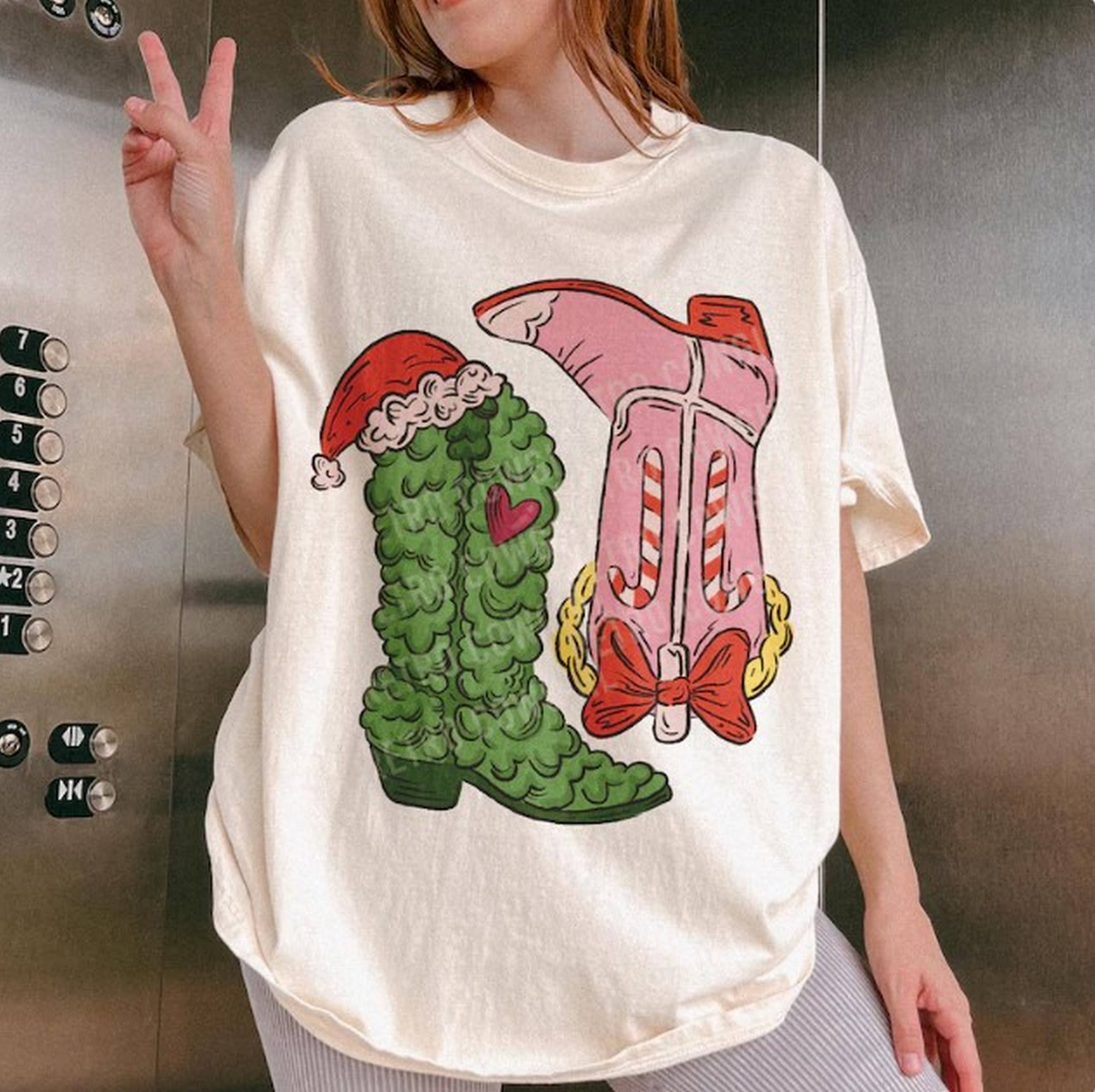 Black Griinchhh Cowboy BootsTee Shirt, Cowgirl Christmas Tee, West for wholesale on Faire