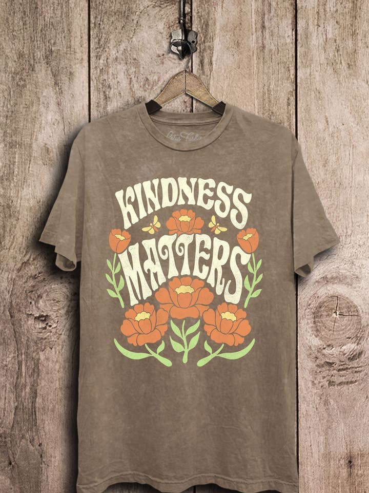 Top con grafica Kindness Matters per la vendita all'ingrosso da parte di Lotus Fashion Collection