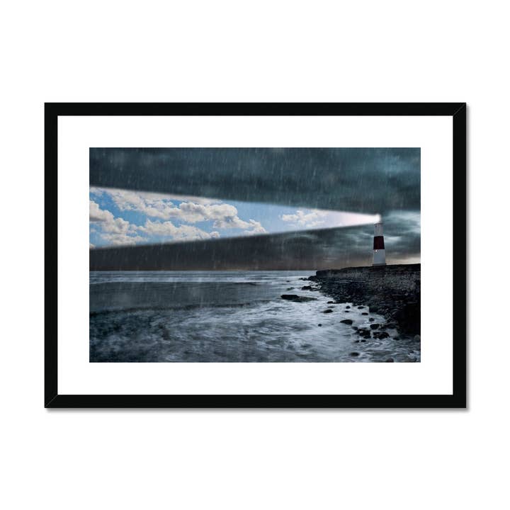 Lighthouse emitting beam of blue sky in a storm Framed & Mounted Print for wholesale by Sorbey