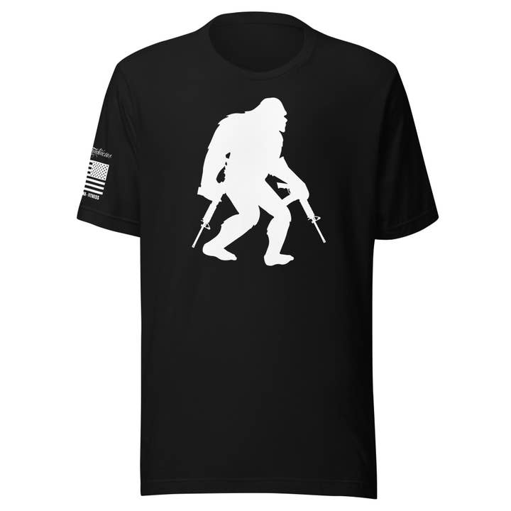 «Bigfoot with Guns» - T-shirt unisex a maniche corte per la vendita all'ingrosso da parte di Killer Tendencies LLC
