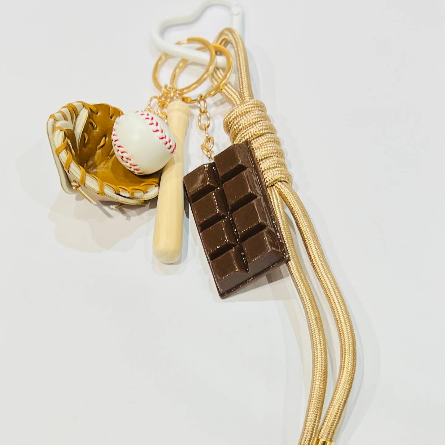 Bijoux 7bis – Engroshandel Nøglering - Dame – Nøglering med baseballhandske, bat, bold, chokolade og beige flettet snor0