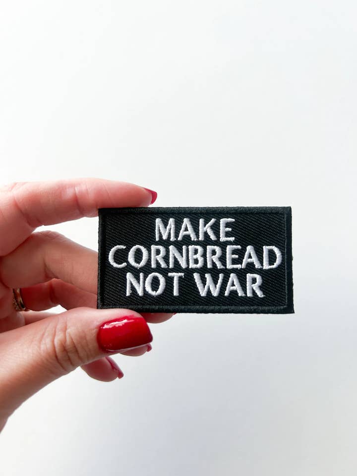 Embroidered "Make Cornbread Not War" Black Iron-on Patch for wholesale by Field Trip Threads