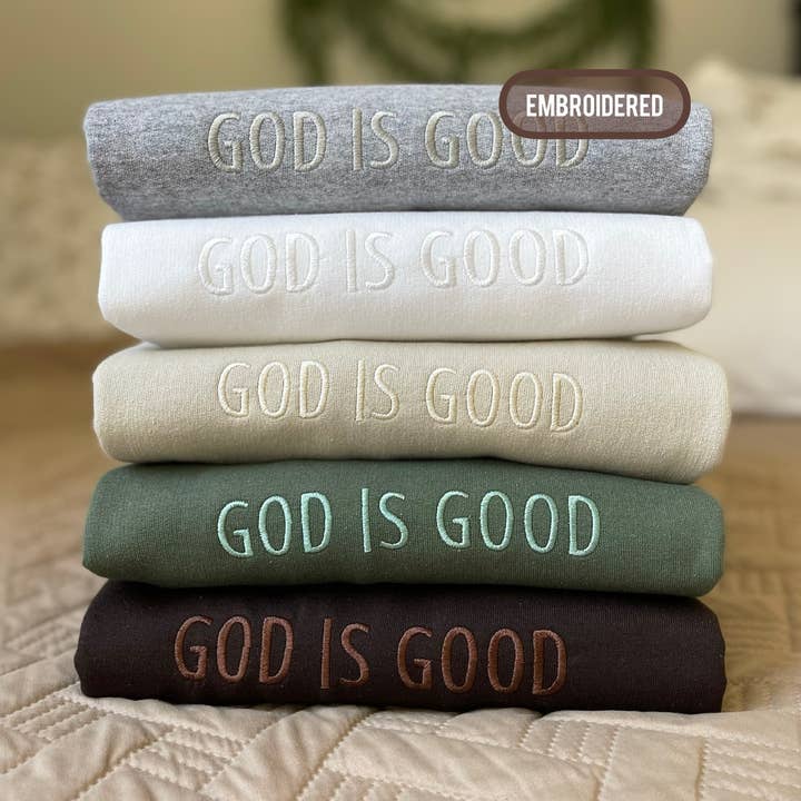Ton-i-ton broderad unisex tröja med tryck 'God is Good' för wholesale av Buleana Boutique and Textiles LLC