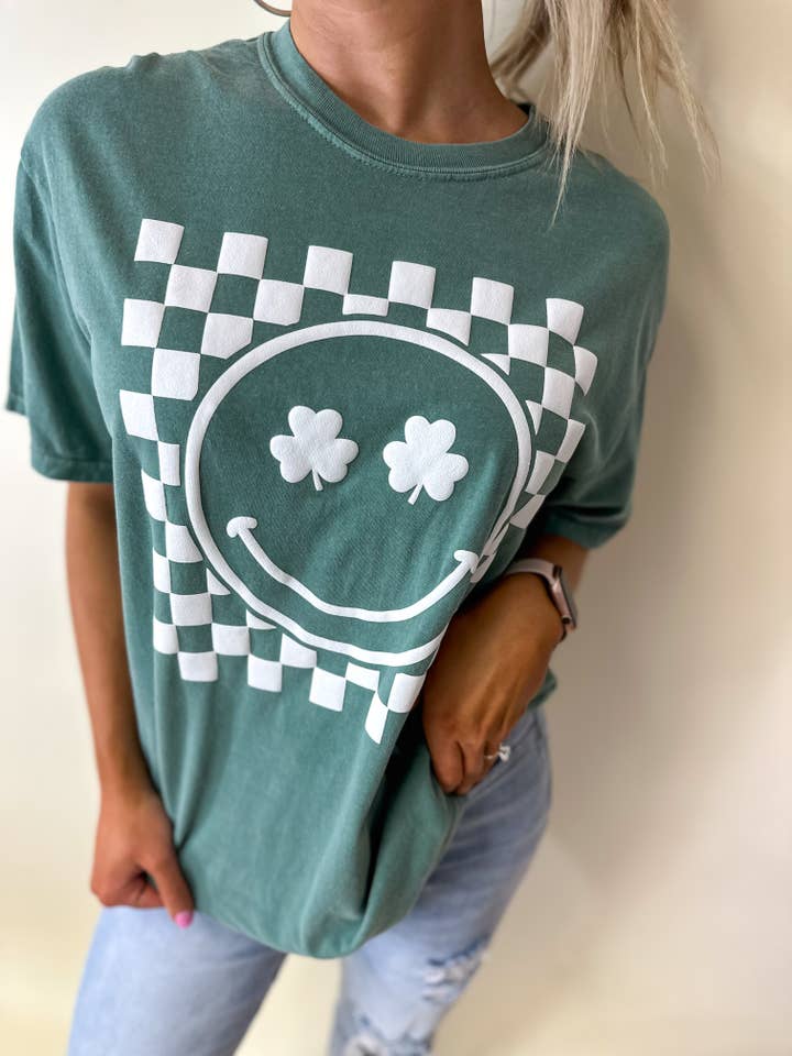 Checkered Shamrock Smiley Green Graphic Tee for wholesale by birdie