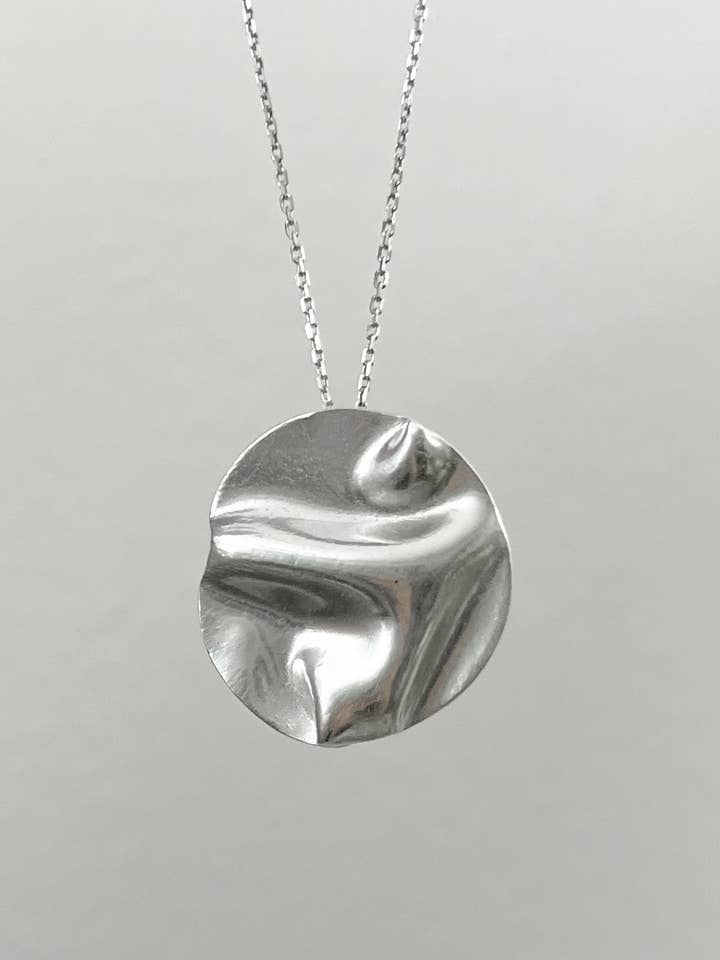 Large wavy circle charm necklace in sterling silver for wholesale by Tina Welsch Jewelry