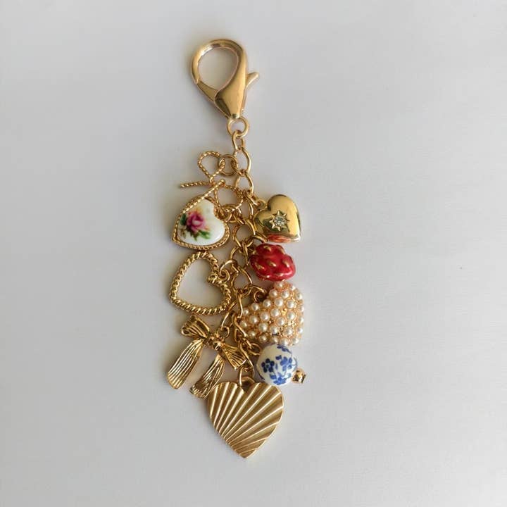 Gold PORCELAIN BOWS HEARTS PEARL STRAWBERRY BAG CHARM | 80K008 for wholesale on Faire