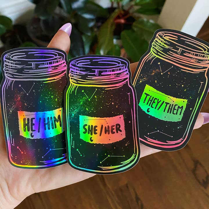 Holographic Pronoun Stickers (she/her) (he/him) (they/them) for wholesale by Jess Weymouth