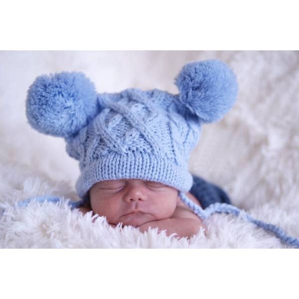 Chapeau cadeau à la main en crochet à pompon en forme de câble bleu bébé pour la vente par The Daisy Baby LLC