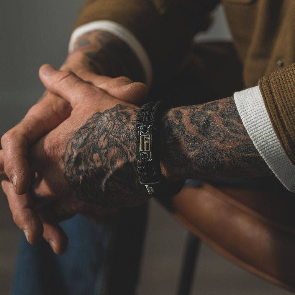 The Hero Company - Wholesale Woven/Braided Bracelet - Never Forgotten Black Paracord Bracelet: Helps Pair Veterans With A Service Dog Or Shelter Dog -Faire8